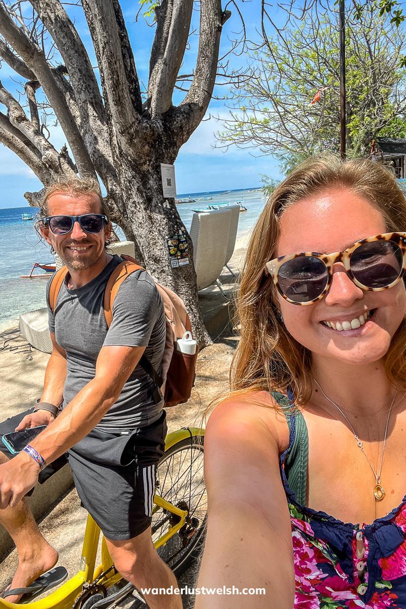Selfie of a couple riding yellow bikes near a beach