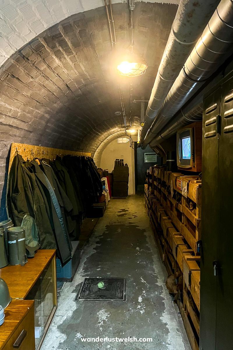 A cold war bunker with old cold-war era memorabilia like clothing, furniture, and tube TV