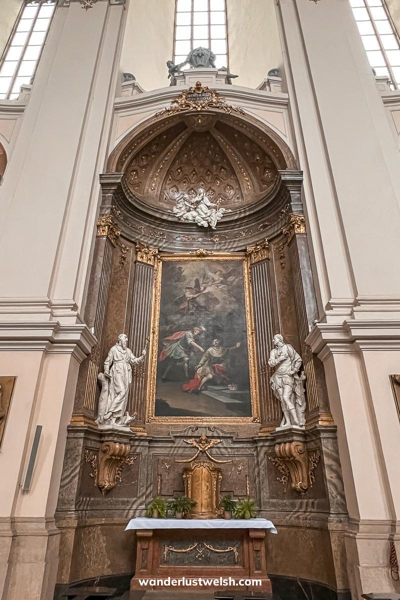 Inside a cathedral - A domed archway with oil painting and small statues