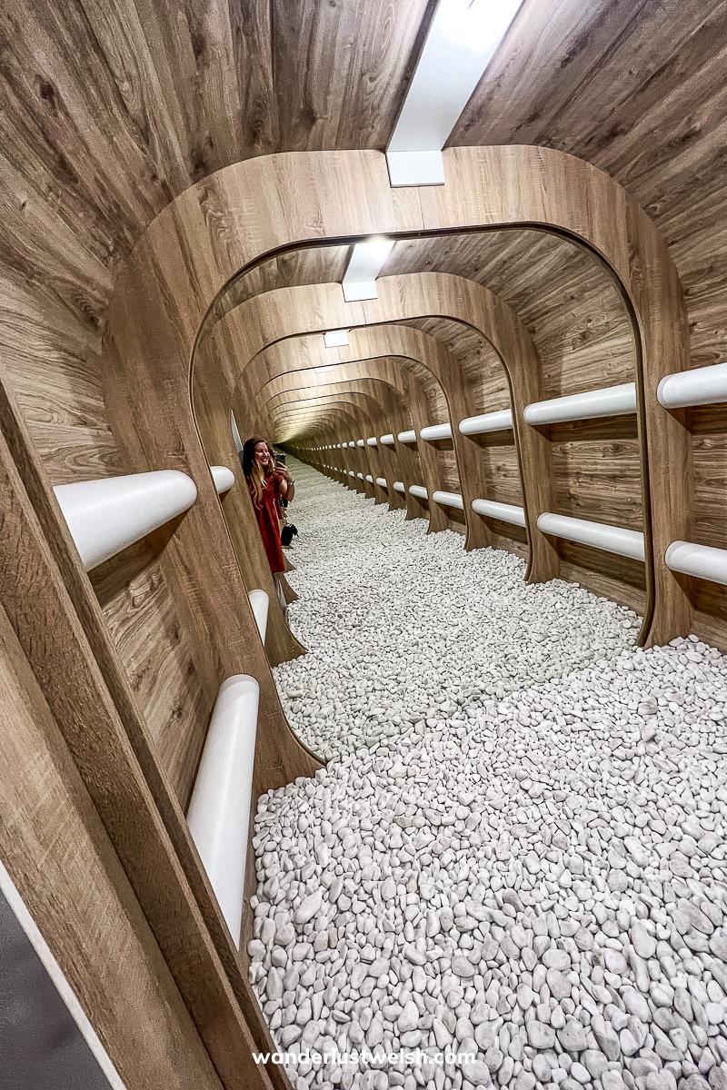 A woman in an optical illusion room of endless depth using mirrors