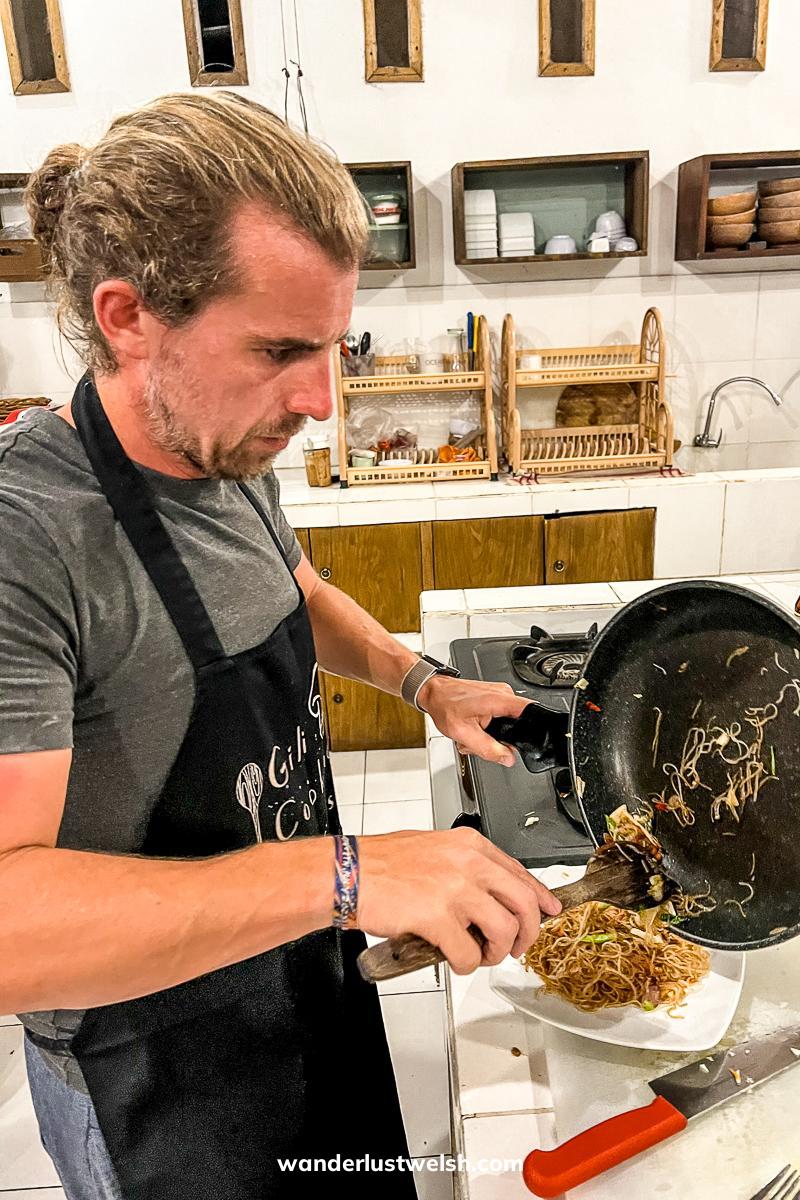 A man serving noodles in a Gili Islands cooking class