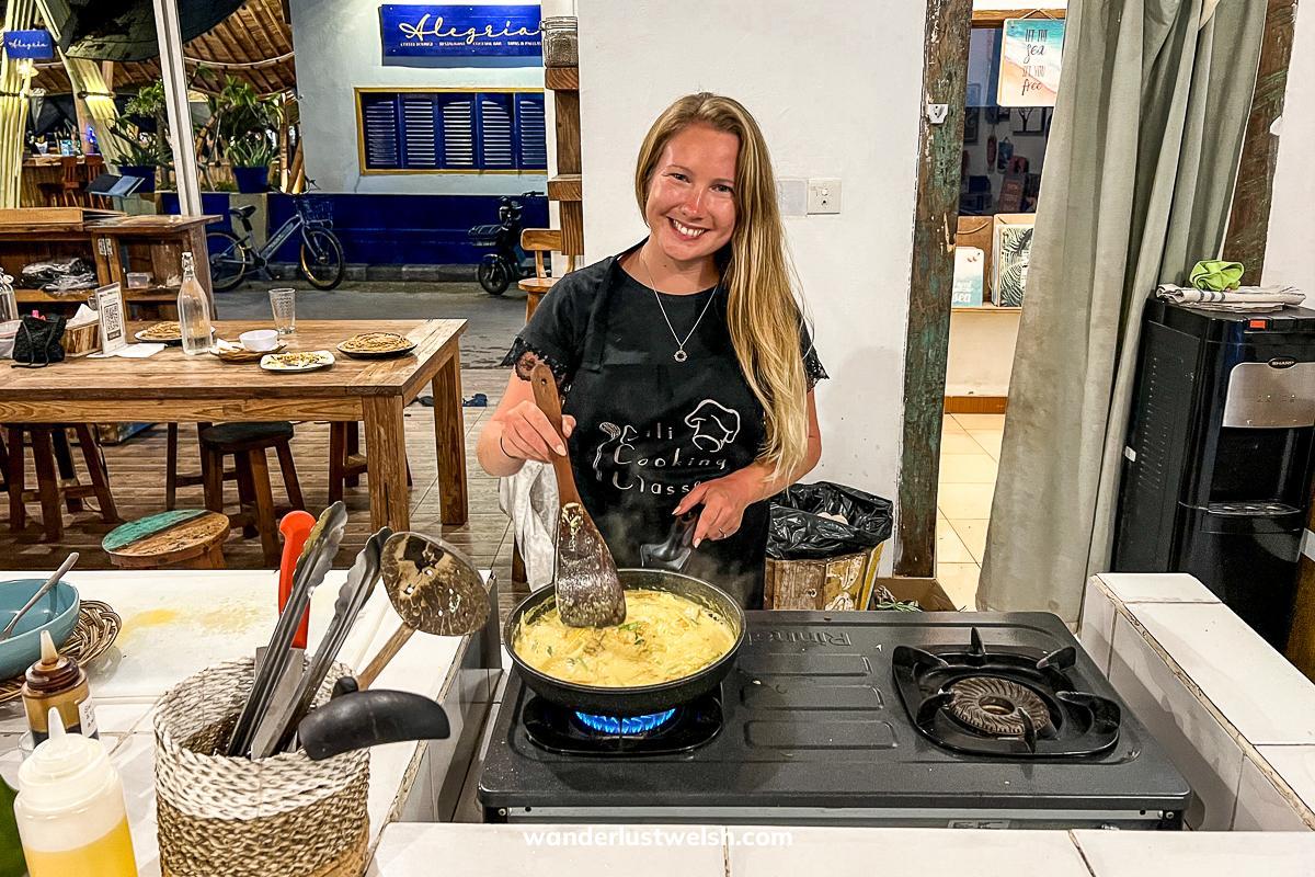 A woman cooking a yellow curry in a Gili Islands cooking class