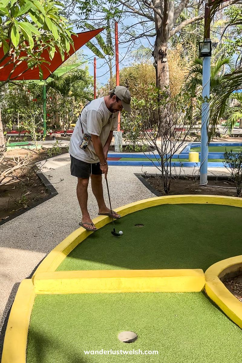 A man playing mini golf on a colorful course