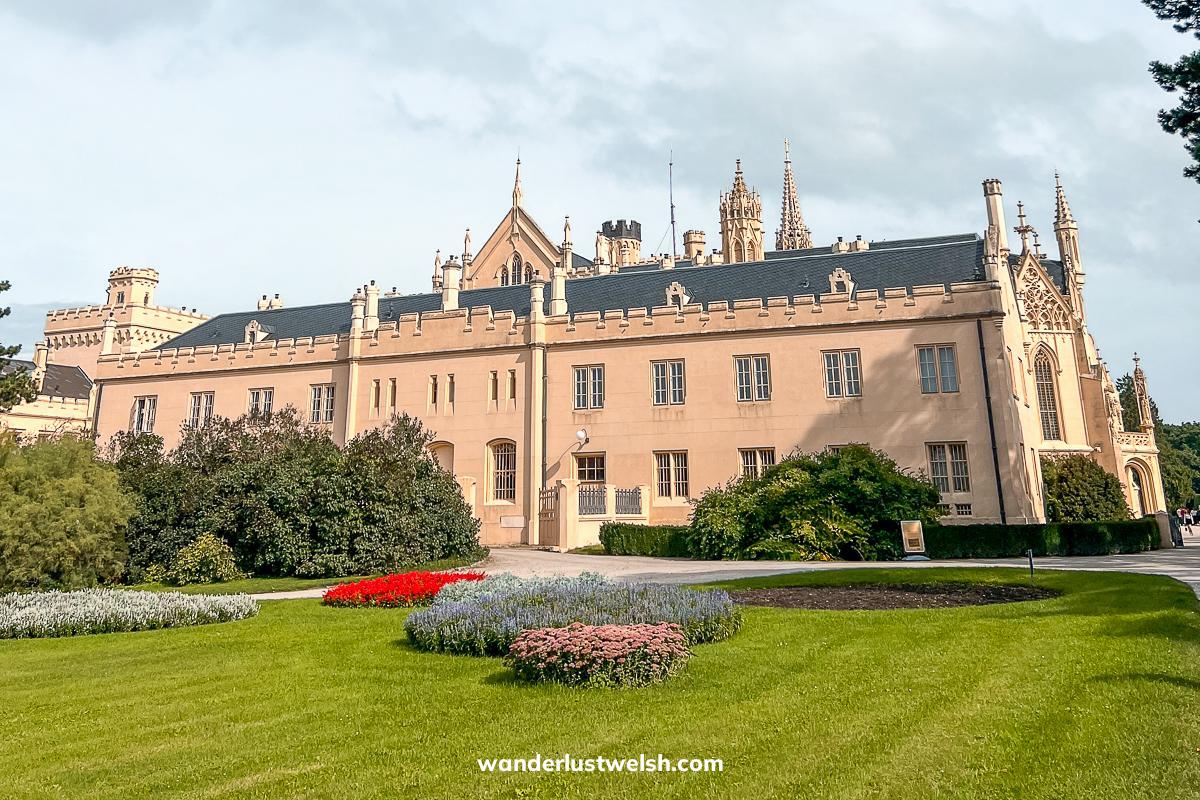 Lednice Castle - A pinky colored two storey modern looking castle with manicured lawns