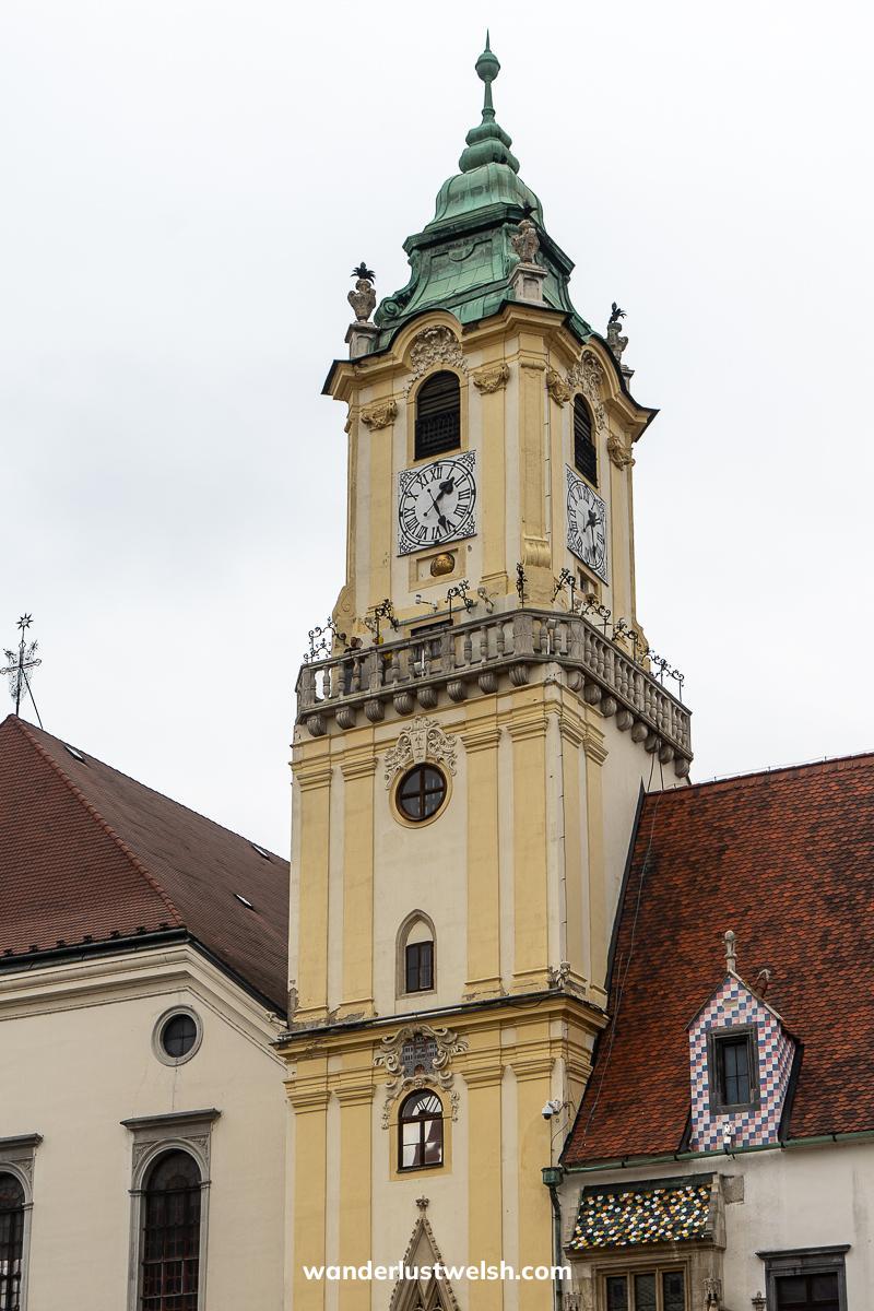 An old clock tower on a town hall - cream tower with green copper roof