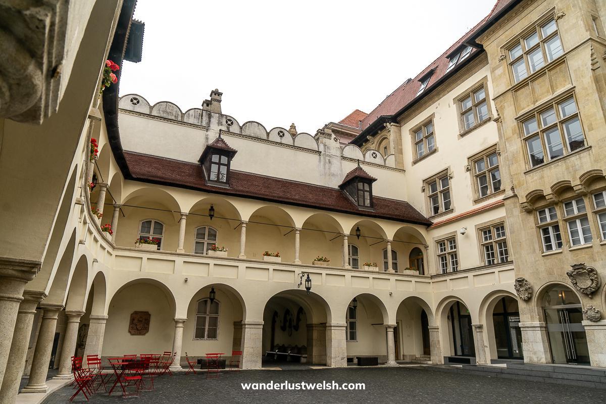 Courtyard of a town hall in Bratislava - a cream colored building with dark red roof