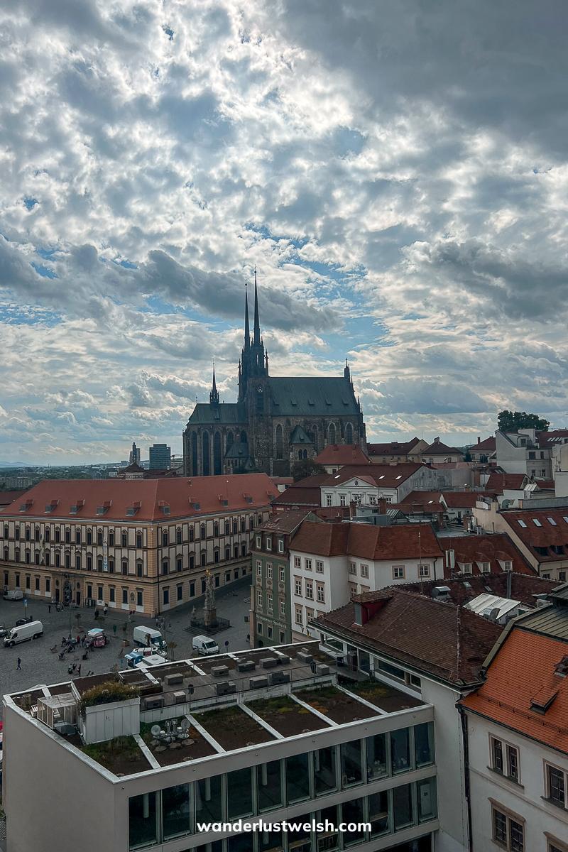 A city view over Brno, the skyline dominated by a double spired cathedral