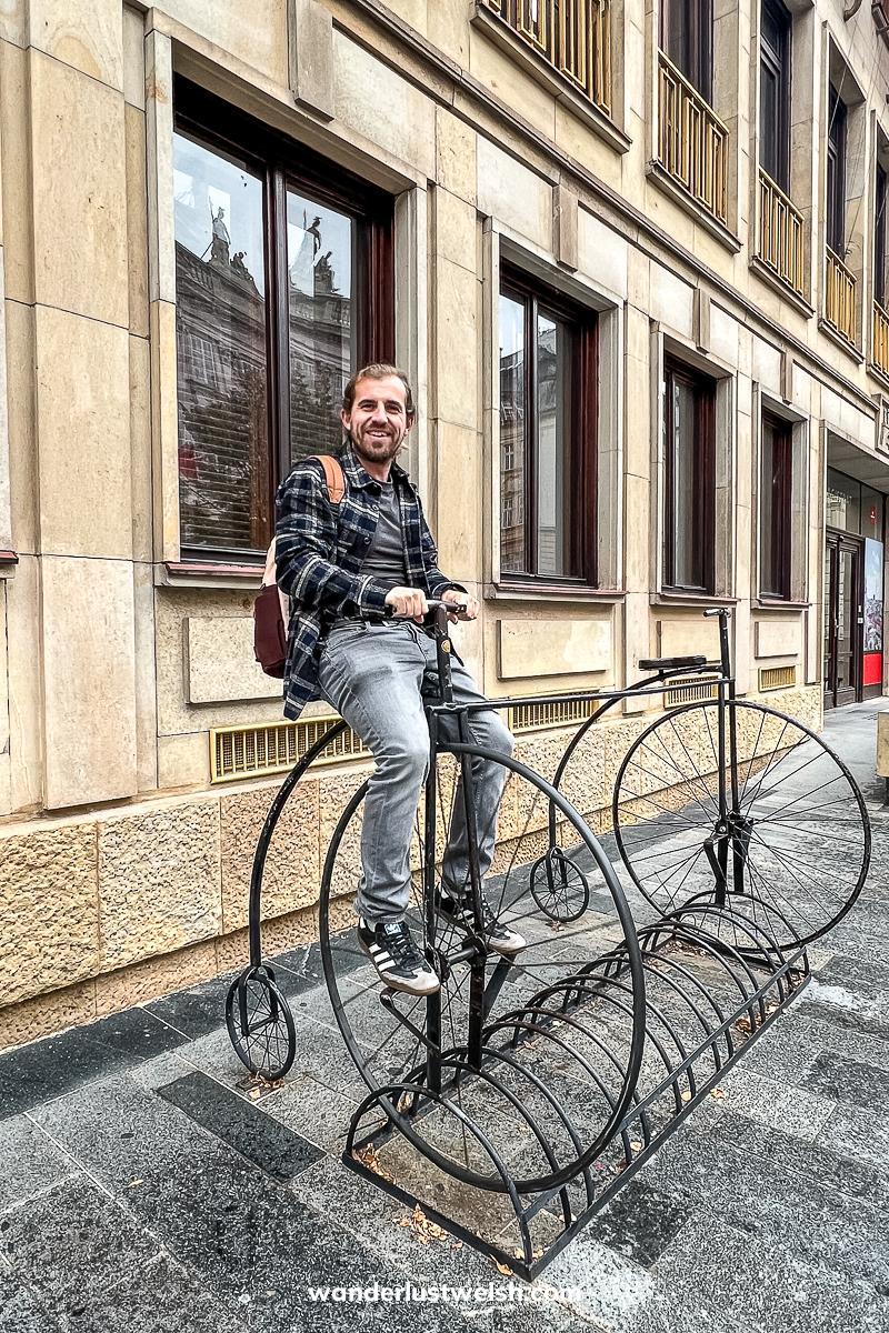 A man sitting on a penny-farthing bicycle statue