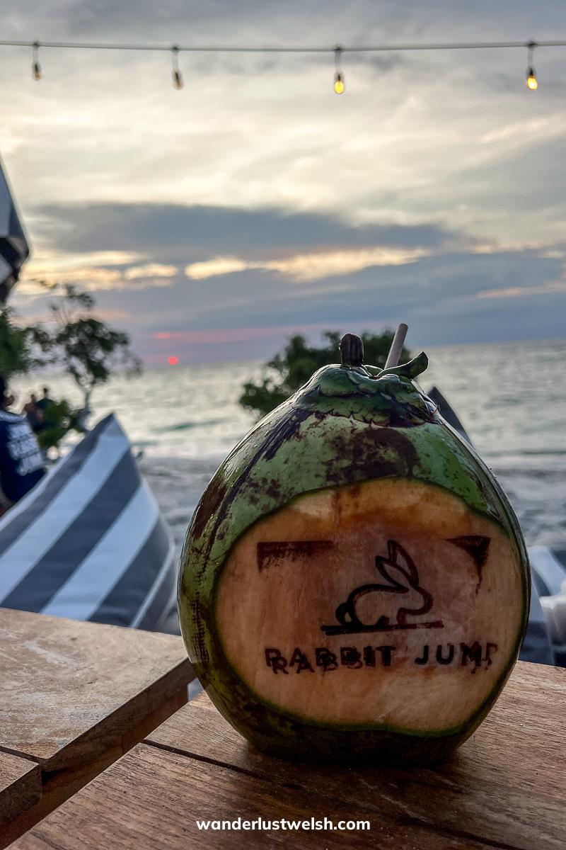 A fresh coconut with "Rabbit Jump" and a picture of a rabbit burnt into it