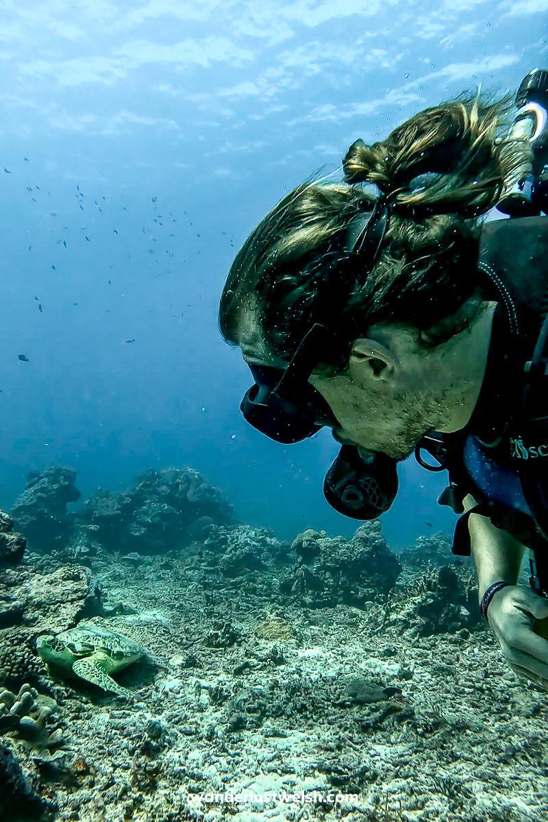 A selfie of a man scuba diving with a turtle