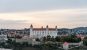 A wide view of Bratislava castle - a white castle with orange roof - and some of the city