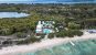 Drone shot of Gili Meno - An inland lake surrounded by trees, a resort, the shoreline and sea