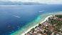 Aerial shot of a tropical island with long sandy shoreline and shallow reefs