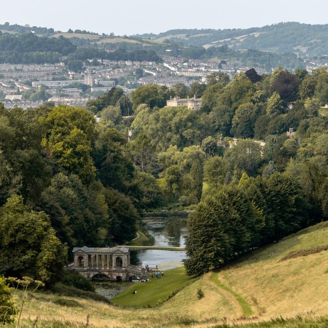 A view of Bath from Prior Park with a lake and Palladian Bridge in the foreground