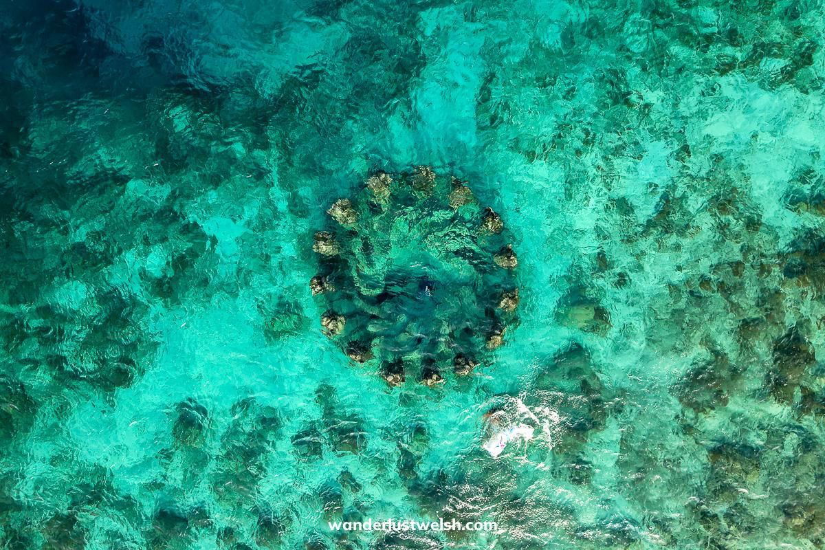 A drone shot of a ring of underwater statues in the Gili Islands