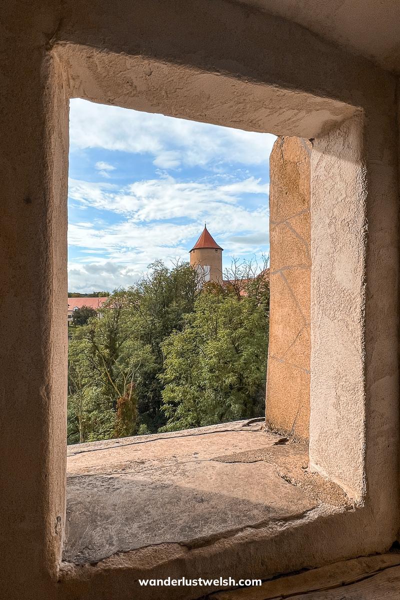 A castle tower viewed from a stone window