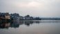 Lake Kivu in Bukavu, DRC under a hazy sky, with houses and trees along the lakeside