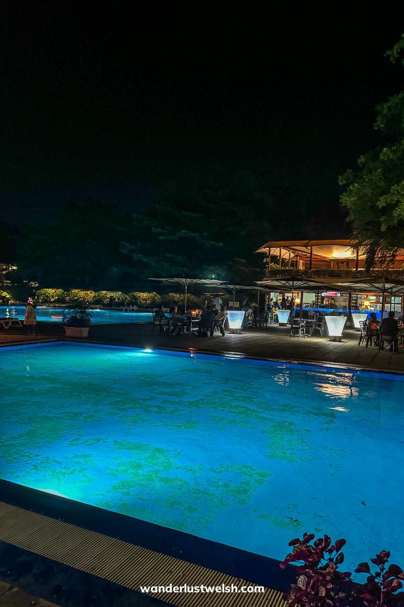 Illuminated outdoor pool at night in Hotel Du Lac Tanganyika