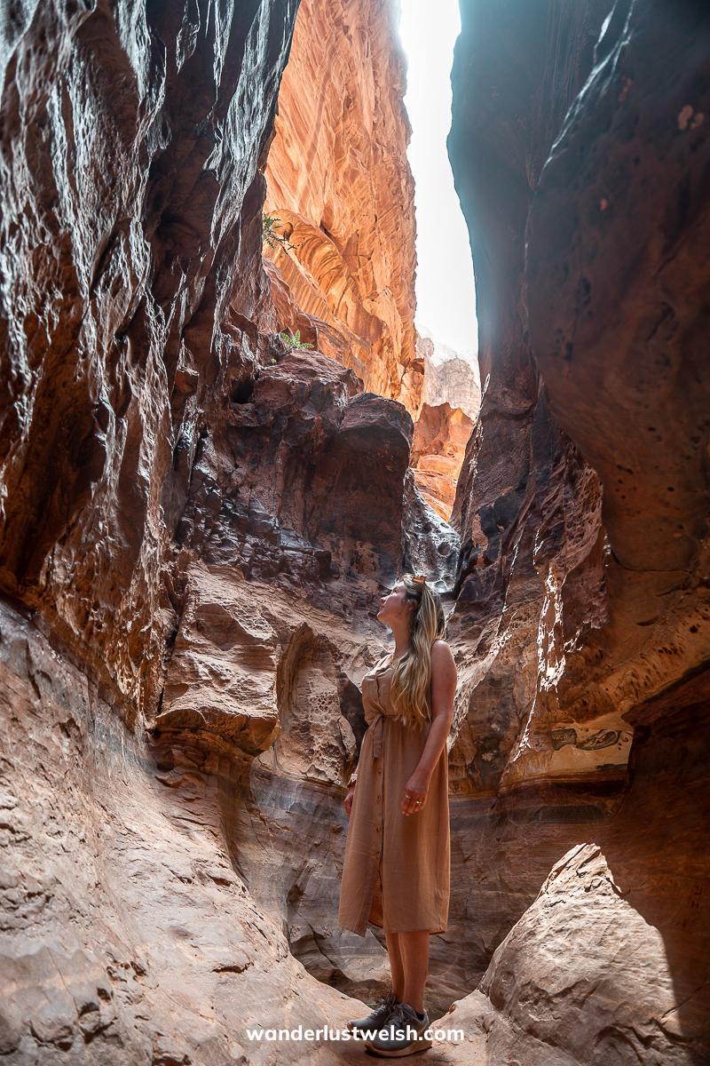 A woman standing admiring a rocky canyon in Wadi Rum