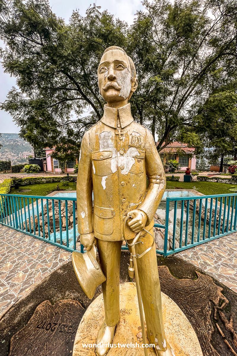 A statue of Richard Kandt in a suit and holding a cane and bowler hat
