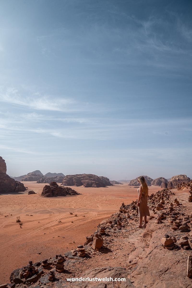 A woman standing looking out over the red desert sands of Wadi Rum