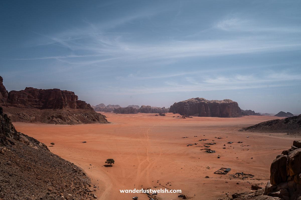 A panoramic view of Wadi Rum - Red desert sands dotted with rocky outcrops