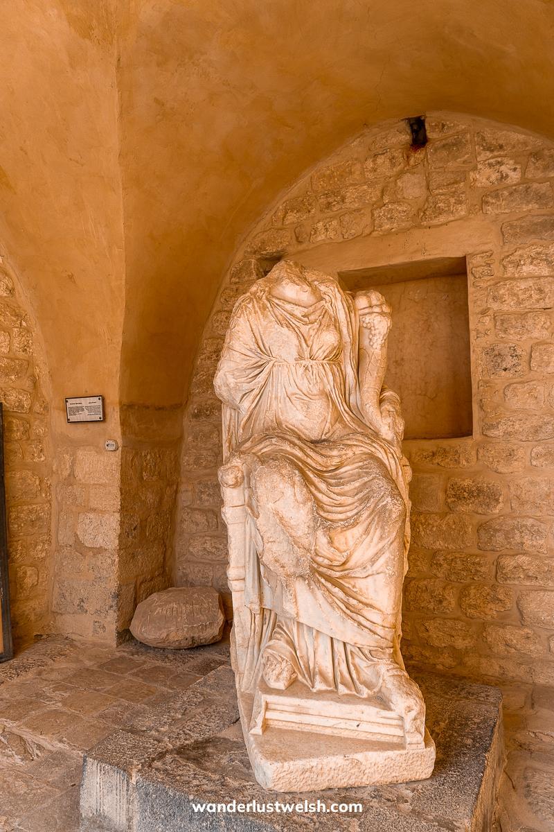 A sandy colored statue in underground mausoleum