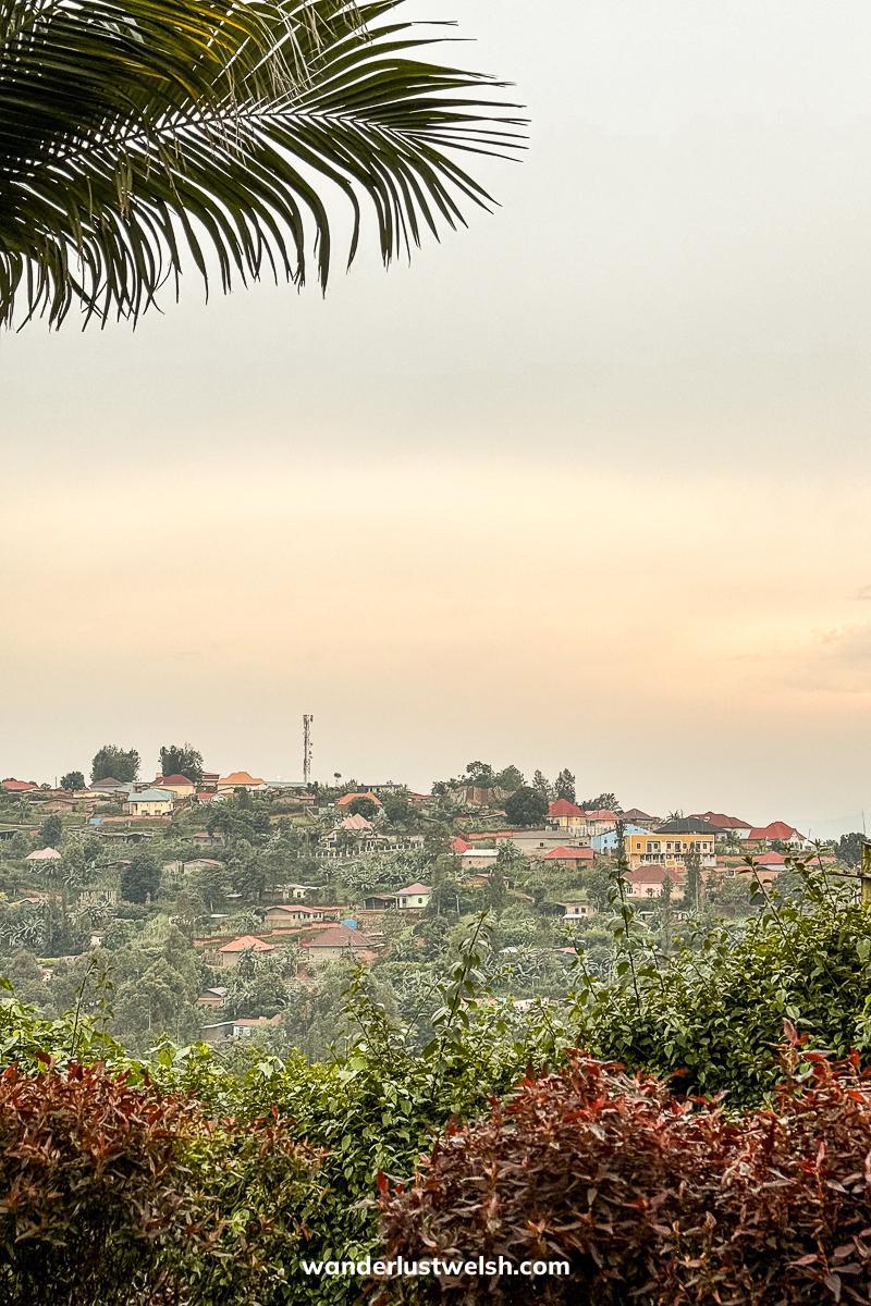 A Congolese town viewed from Rwanda framed by trees and bushes